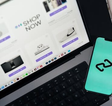 A smartphone and laptop displaying online shopping platforms, suggesting digital retail.